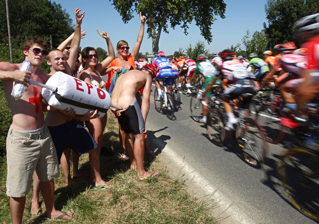 Szurkolók utalnak egy fenékbe szúrt műfecskendővel a kerékpárosok EPO-használatára a Tour de France-on