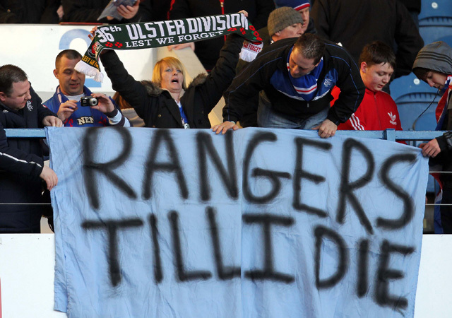 A Glasgow Rangers szurkolója feszít ki egy klubot támogató transzparenst az együttes bajnoki mérkőzésén 2012-ben.