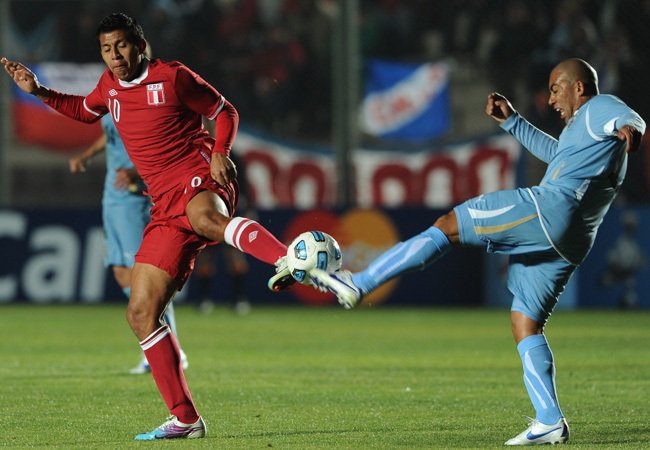 Peru és Uruguay játékosa küzdenek a labdáért a két csapat Copa América mérkőzésén 2011 júliusában.