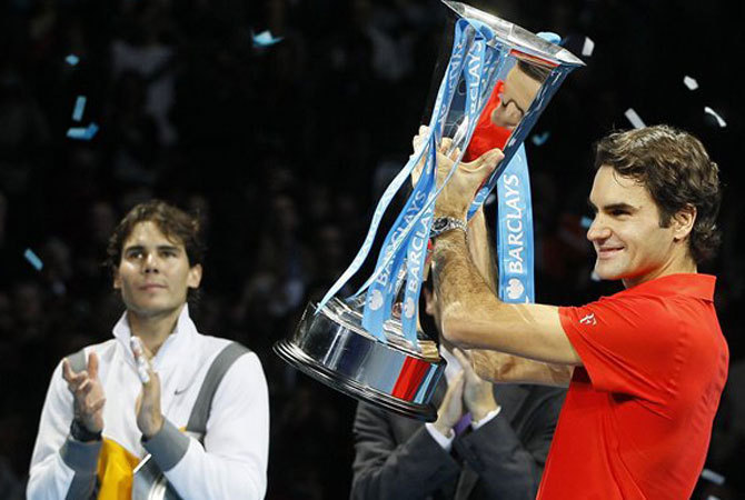 Federer az ATP Finals kupával Nadal a háttérben