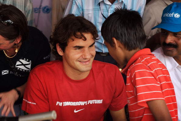 Roger Federer 16-szoros Grand Slam-győztes teniszező egy gyerekkel beszélget. 
