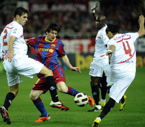 Lionel Messi lő három védő között a Sevilla-Barcelona mérkőzésen