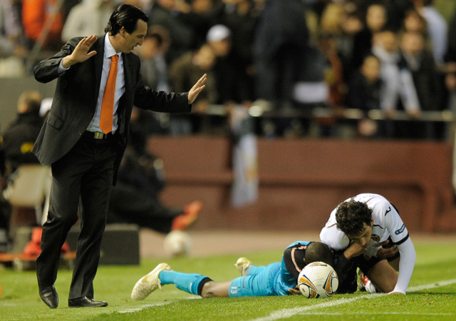 Unai Emery, a Valencia vezetőedzője nézi, amint játékosa a PSV játékosával küzd a két csapat Európa Liga-meccsén 2012-ben.