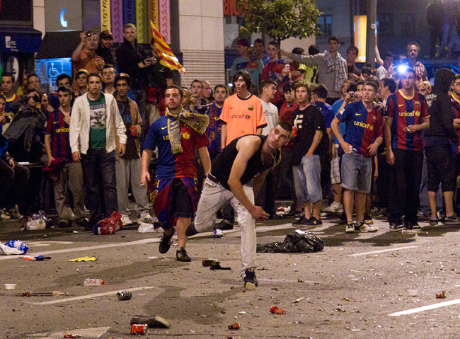 Barcelona-szurkolók dobálják a rendőröket Barcelonában, miután a csapat megnyerte a Manchester United elleni BL-döntőt 2011 májusában