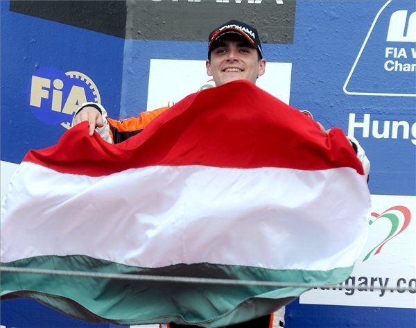 Michelisz Norbert áll magyar zászlóval a kezében a dobogón a Hungaroringen rendezett túraautó-világbajnoki futam első futama után 2011 májusában