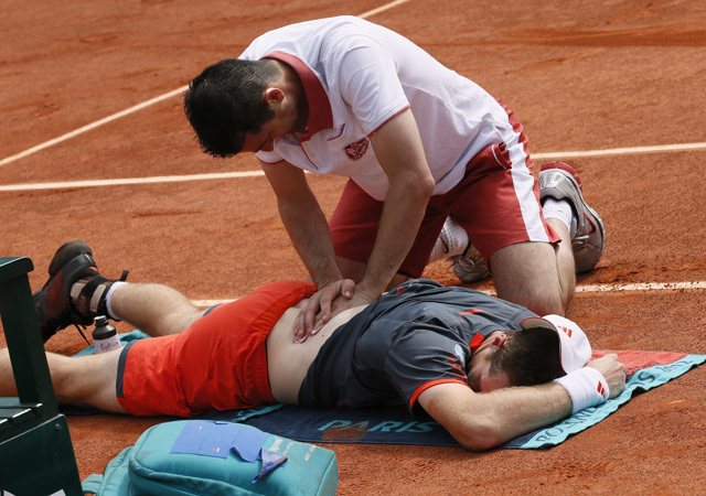Andy Murrayt ápolja a gyúró a Roland Garroson 2012-ben a Jarkko Nieminen elleni mérkőzésen.