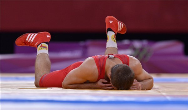 Lőrincz Tamás (pirosban) a földön fekve kesereg, miután kikapott a dél-koreai Kim Hjon Vu ellen a férfi kötöttfogású birkózók 66 kg-os súlycsoportjának döntőjében a 2012-es londoni nyári olimpián, az ExCel központban 2012. augusztus 7-én. A magyar versenyző ezüstérmes lett. MTI Fotó: Illyés Tibor 