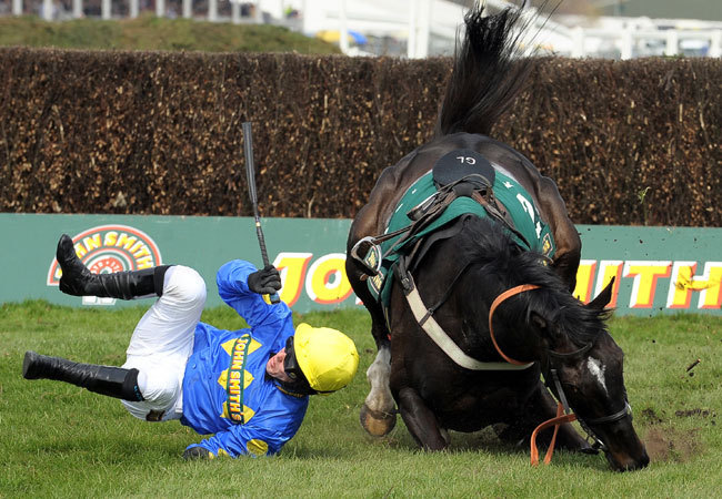 Ló és lovasa esik el egy akadály mögött a 2010-as Grand National lovasversenyen