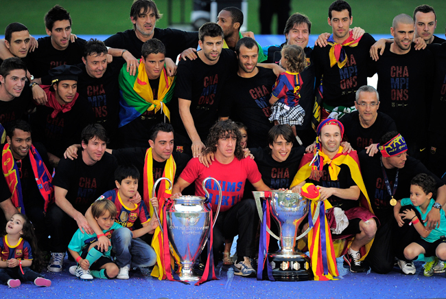 A FC Barcelona csapatának tagjai ünnaplik a bajnoki címet és a Bajnokok Ligája serleget a Camp Nouban.