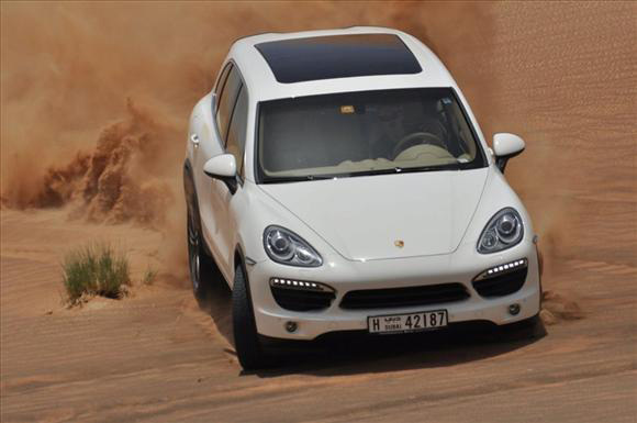 Adam Malysz, korábbi lengyel síugró vezet egy Porsche Cayenne terepjárót a sivatagban az Egyesült Arab Emirátusokban, ahol a Dakar rali nevű terepraliversenyre készül 2011 augusztusában