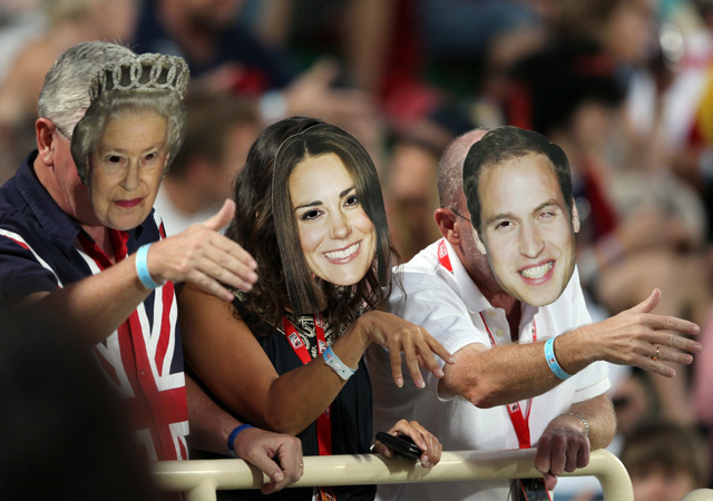 II. Erzsébet királynő, Vilmos herceg és Katalin hercegnő fényképeit viselő szurkolók a Sevens Ruby World Series egyik elődöntőjén
