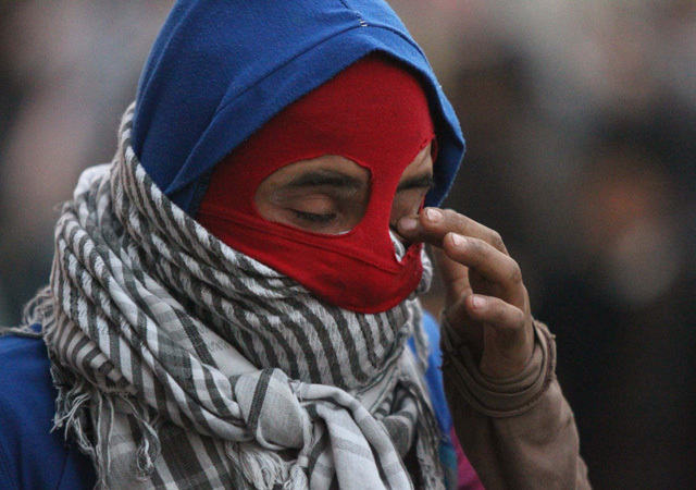 Egyiptomi tüntető dörzsöli a szemét Kairóban, miután könnygázgránátokat lőttek ki rá rendőrök egy tüntetésen 2012-ben.