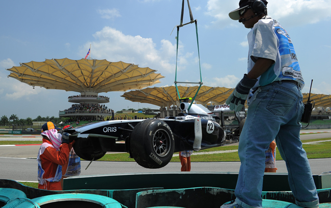 Pastor Maldonado Williams-Cosworthét emelik ki a pályamunkások a Malajziai Nagydíj edzésén.