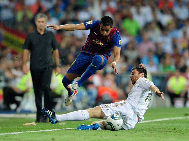 A chilei Alexis Sánchez, a Barcelona játékosa ugorja át a becsúszó Xabi Alonsót. 