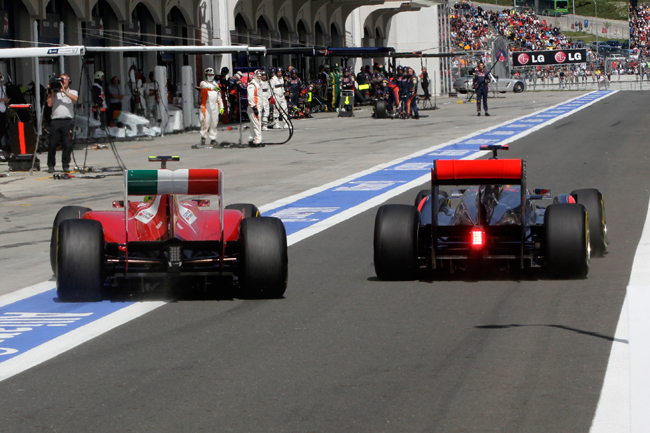 Egy Ferrari és egy McLaren versenyez a boxutcában a Formula-1-es Török Nagydíjon.