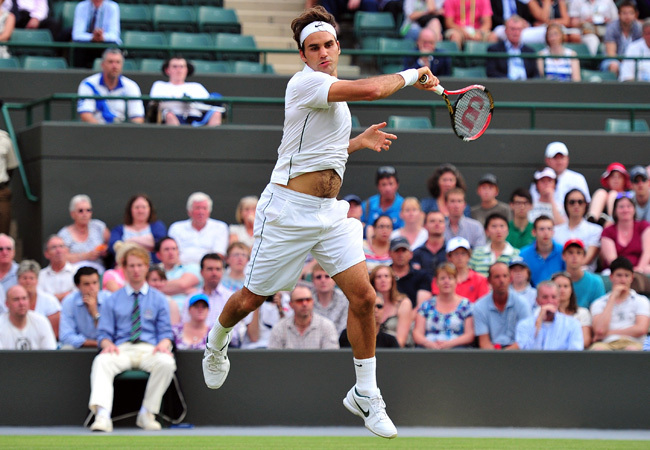 Roger Federer üti a labdát a Mihail Juzsnyij elleni mérkőzésén Wimbledonban 2011 júniusában