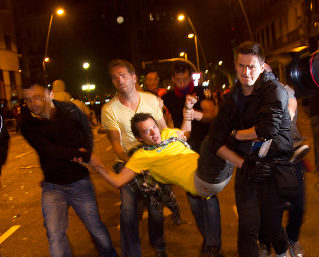 Civil ruhás rendőrök visznek el egy szurkolót, miután a Barcelona-Manchester United BL-döntő után összecsapások törtek ki Barcelona utcáin 2011 májusában