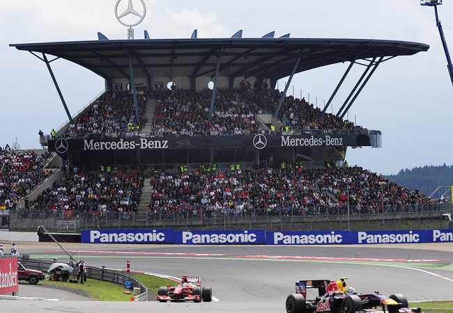 A Nürburgring autóverseny-pálya főlelátója a 2009-es Forma-1-es Német Nagydíjon, előtte Felipe Massa a Ferrari, és Mark Webber a Red Bull versenyzője
