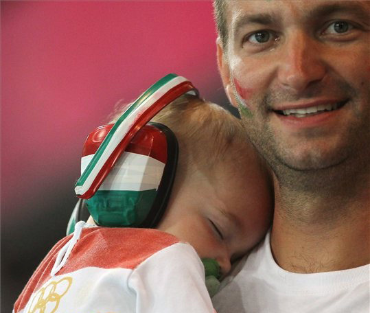 Nemzetiszínű hallásvédőt és ruhát viselő kisgyermekét tartja karjában egy magyar szurkoló a 2012-es londoni nyári olimpia férfi kézilabda-bajnoksága B csoportjának második fordulójában vívott Koreai Köztársaság-Magyarország találkozón a Copper Box kézilabdacsarnokban 2012. július 31-én. A magyar válogatott 22-19 arányban megnyerte a mérkőzést.