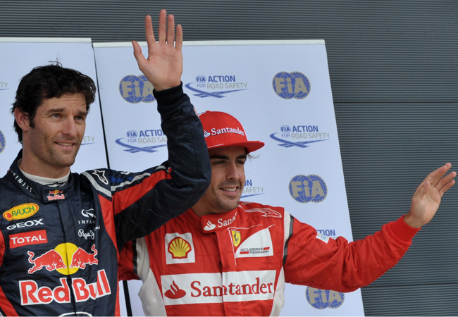 Mark Webber és Fernando Alonso integetnek a közönségnek a Forma-1-es Brit Nagydíj időmérő edzése után 2011 júliusában
