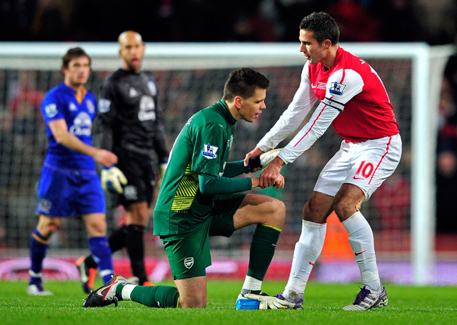 Robin van Persie segíti fel Wojciech Szczesnyt, az Arsenal kapusát, miután az megcsókolta a lábát az Everton elleni Premier League-mérkőzésen szerzett győztes gólja után 2011 decemberében